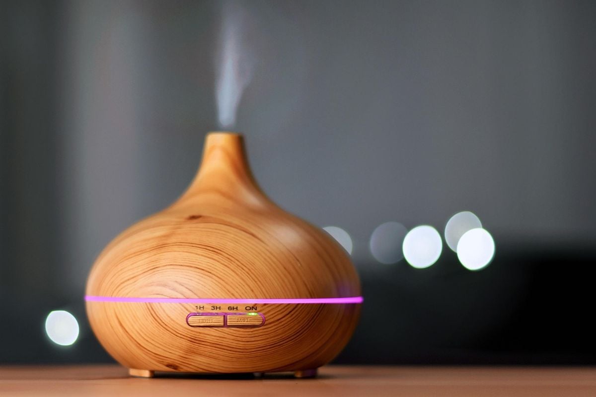 Umidificador de ar em funcionamento para aliviar o ar seco do quarto Umidificador de ar emitindo vapor fino em um quarto