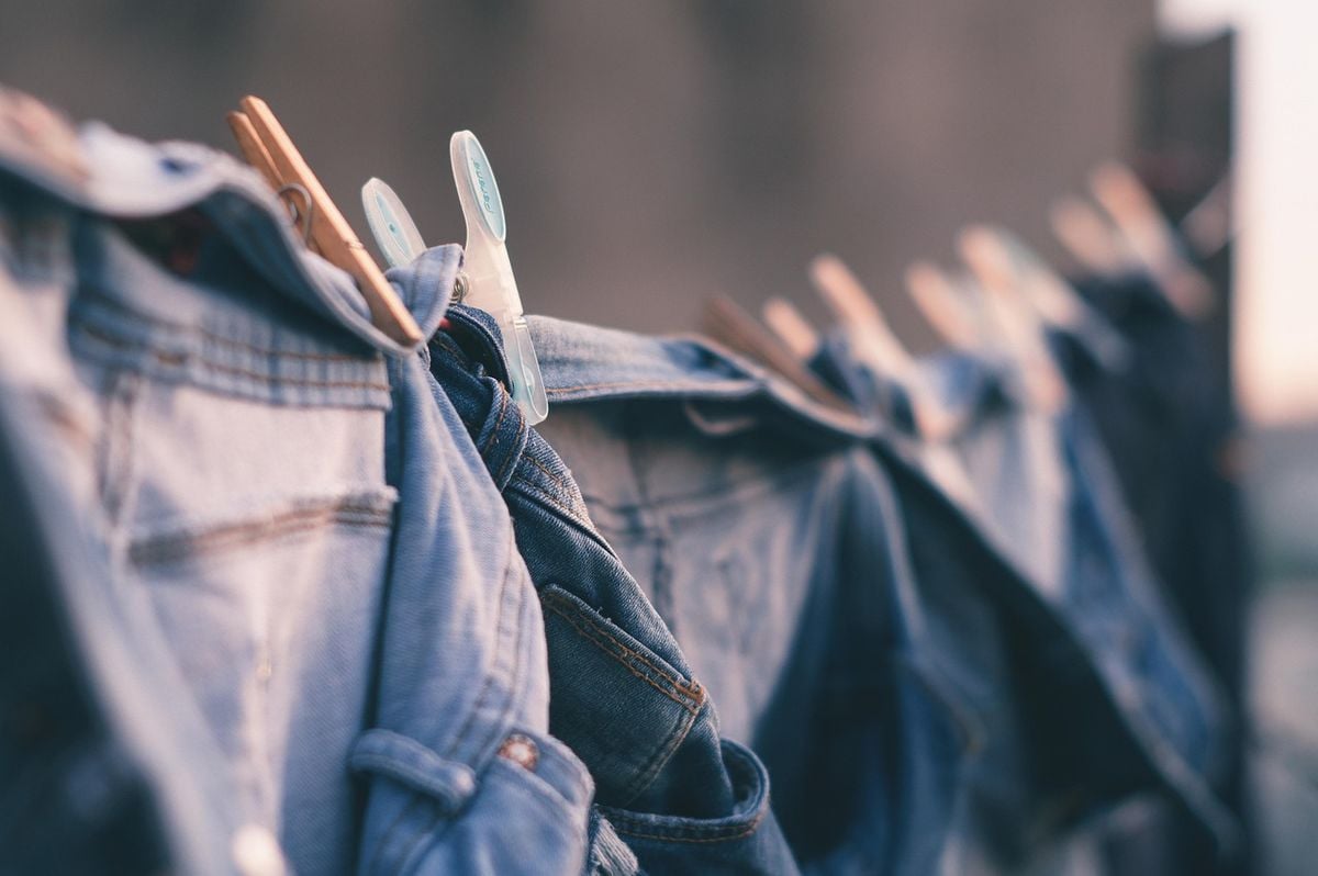 Roupas de jeans penduradas no varal com pregadores, esperando a secagem