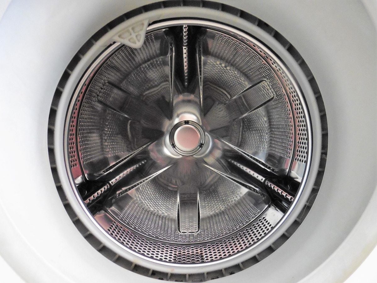 Tambor de máquina de lavar em aço inox visto de cima, peça movida pelo motor inverter