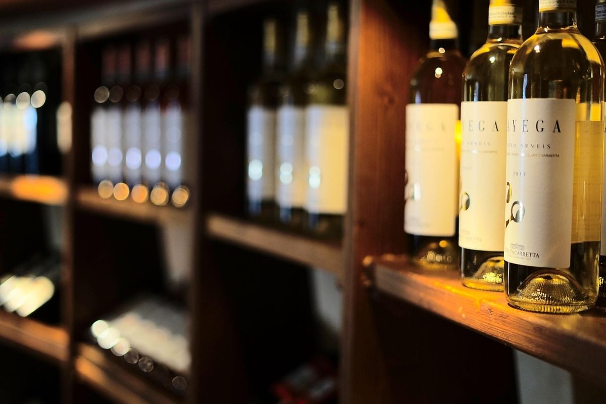 Garrafas de vinho armazenadas deitadas em prateleira de madeira