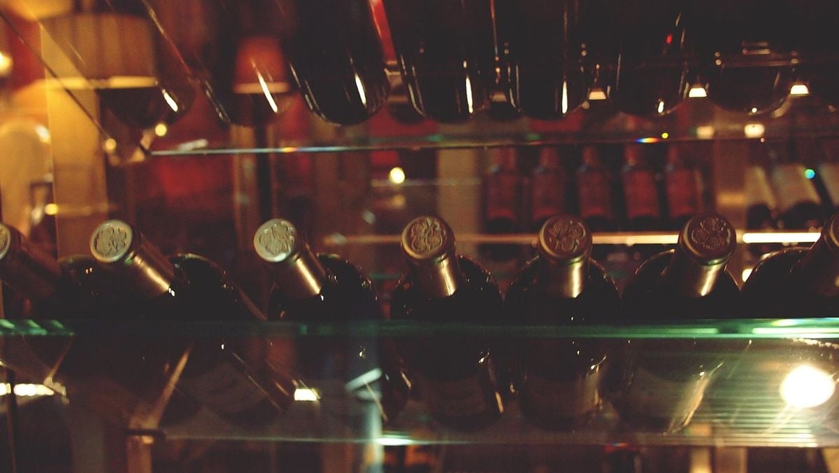 Garrafas de vinho na adega atras da porta de vidro