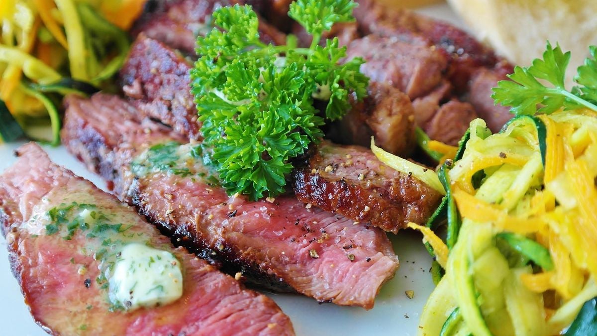 Fatias de carne grelhada e suculenta servidas com chimichurri