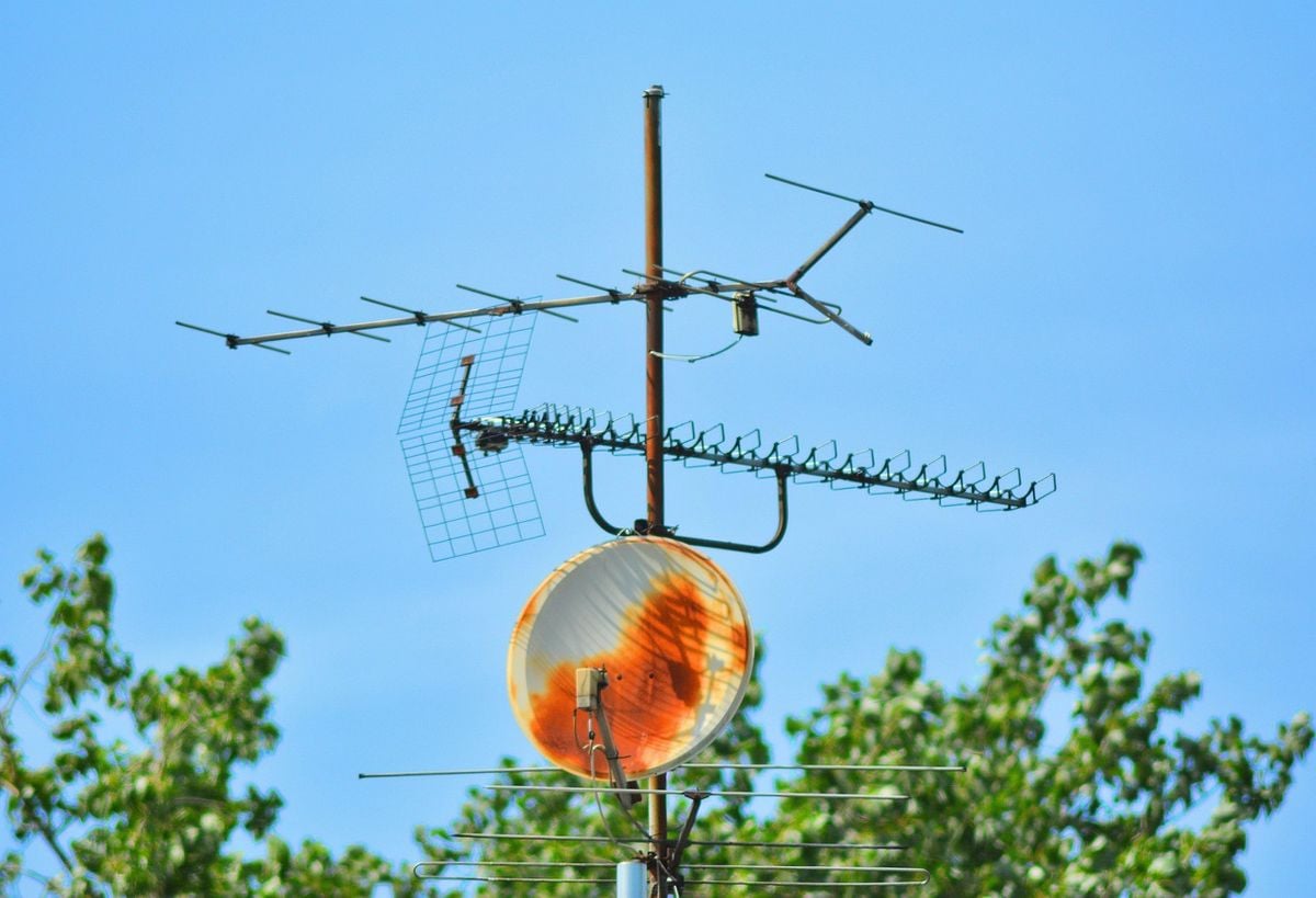 Antenas de TV digital instaladas em um mastro contra o céu azul