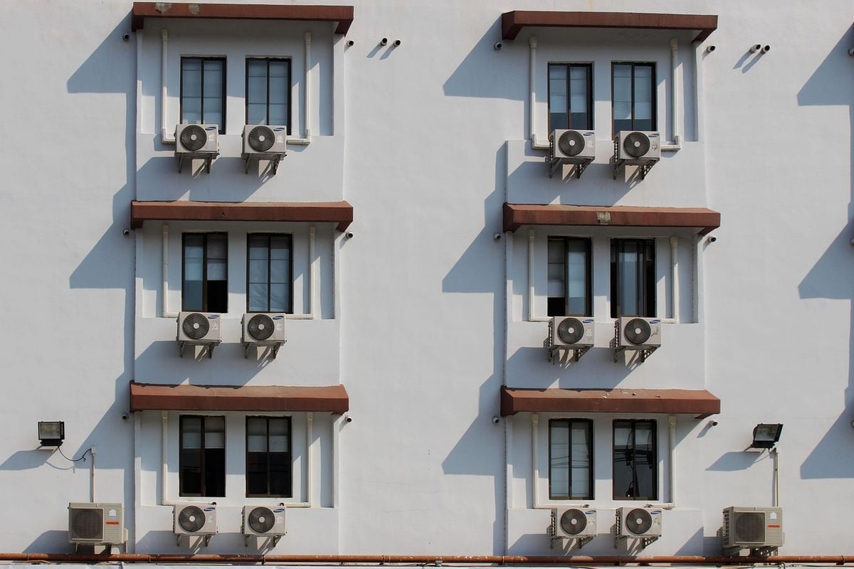 Fachada de prédio com vários aparelhos de ar-condicionado instalados nas janelas