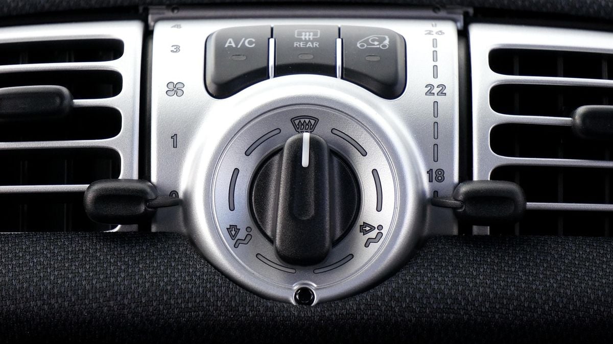 Painel de controle do ar-condicionado de um carro com botão A/C e ventilação