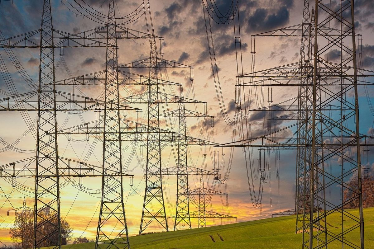 Torres de transmissão de energia elétrica ao pôr do sol representando consumo